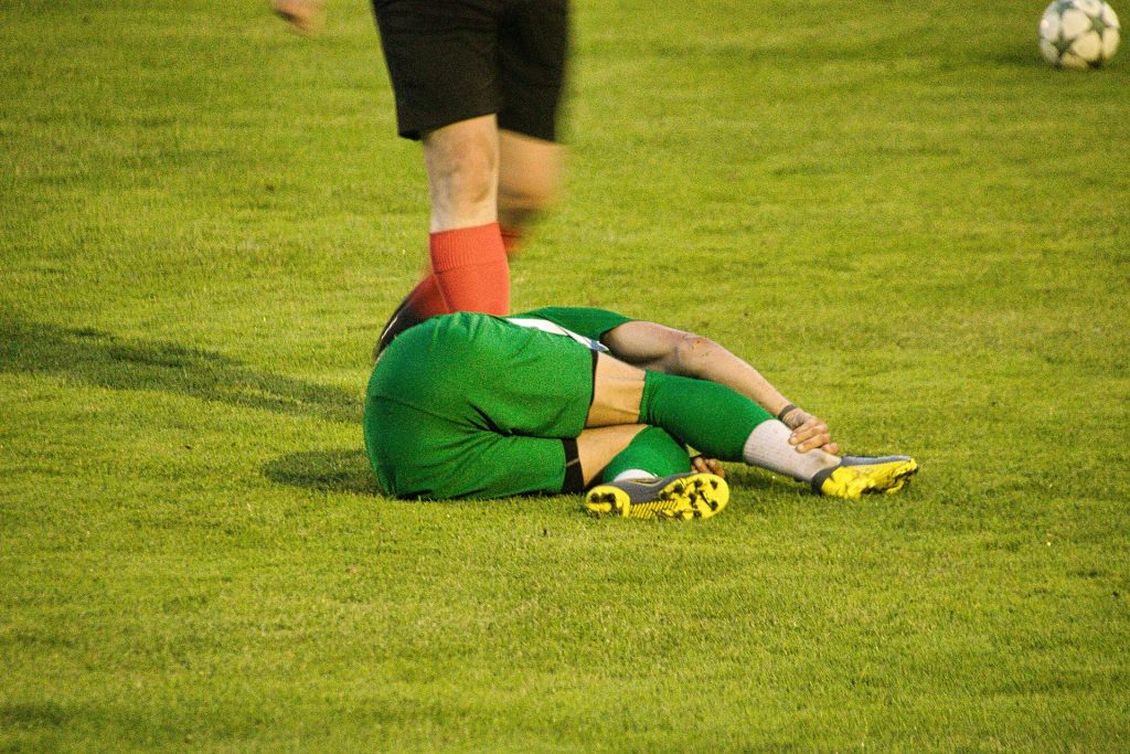 Jogador lesionado em campo de futebol.