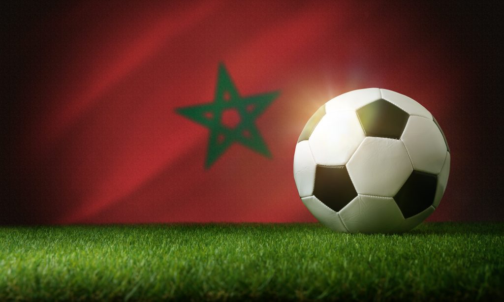 Bola de futebol e bandeira de Marrocos.
